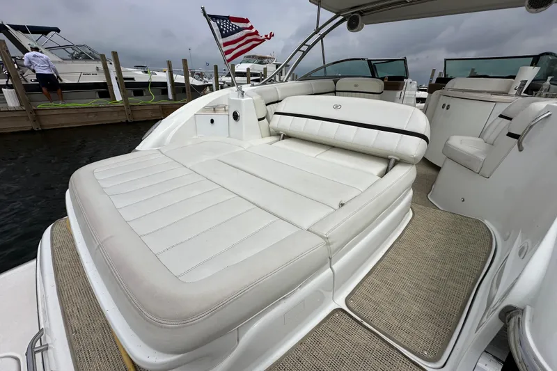 Slide: The Image of 2015 Cobalt 336 boat with white seating, American flag, docked at marina. - 5