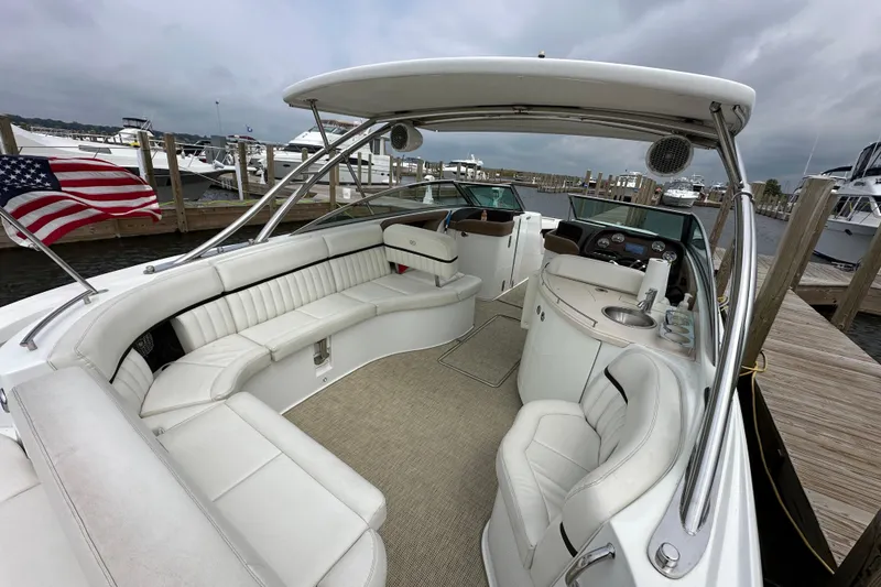 Slide: The Image of 2015 Cobalt 336 boat interior with white seating and American flag at dock. - 6
