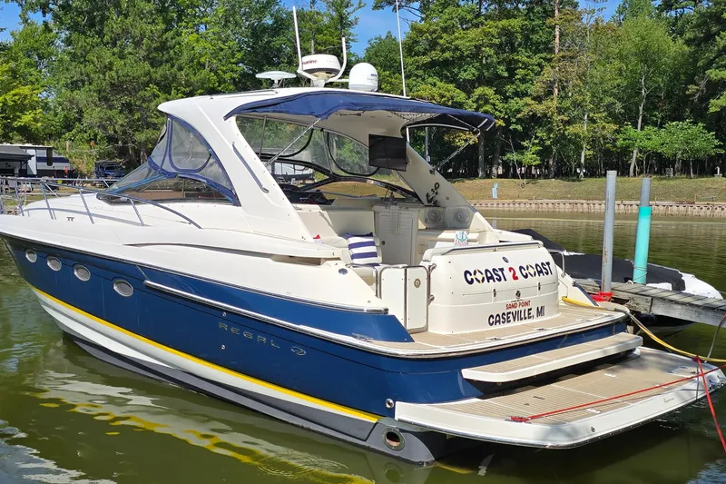 The Image of 2003 Regal Commodore 4260 yacht docked in a serene marina setting. - 1