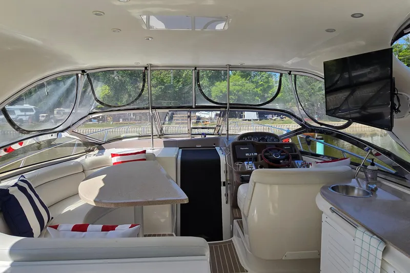 Slide: The Image of Interior of 2003 Regal Commodore 4260 yacht with seating, table, and helm. - 16