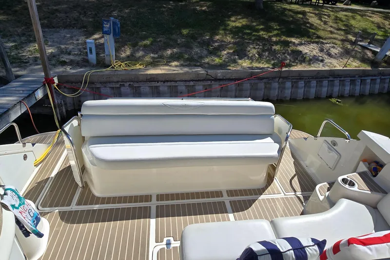 Slide: The Image of 2003 Regal Commodore 4260 boat interior with white seating and dockside view. - 21