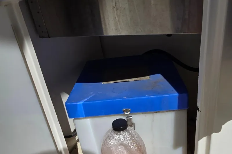 Slide: The Image of Storage compartment in a 2003 Regal Commodore 4260 boat, featuring a blue-lidded container. - 27