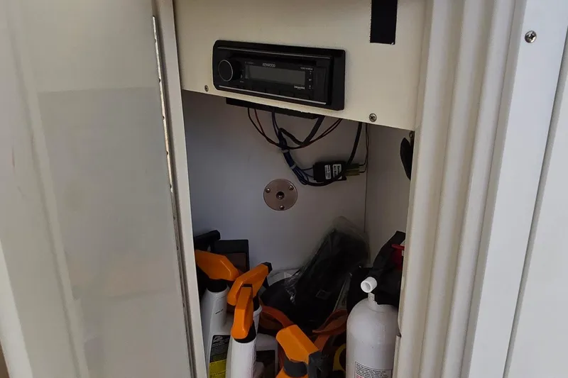 Slide: The Image of Storage compartment in a 2003 Regal Commodore 4260 with stereo and cleaning supplies. - 28