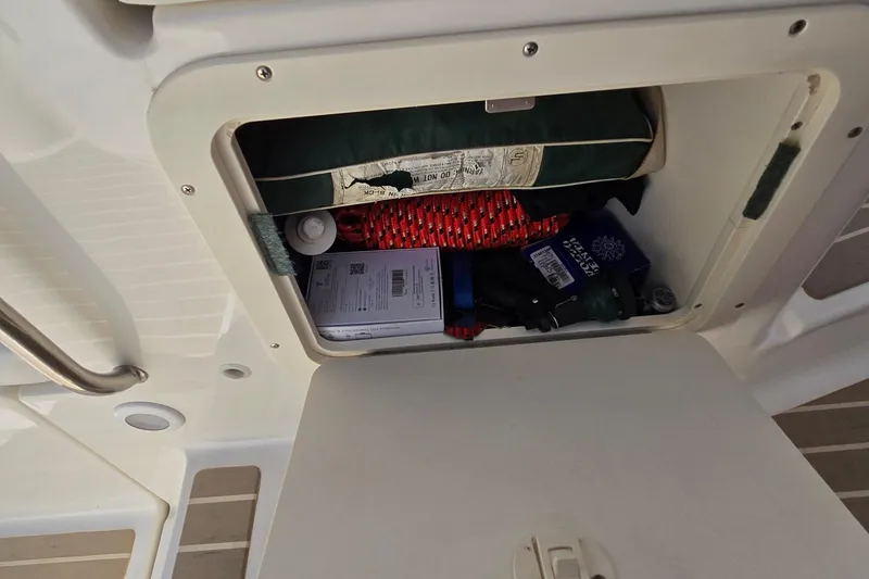Slide: The Image of Storage compartment on a 2003 Regal Commodore 4260 boat with various items inside. - 29