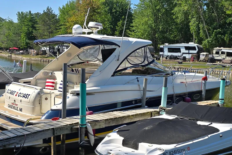 Slide: The Image of 2003 Regal Commodore 4260 yacht docked at a marina with lush green surroundings. - 3