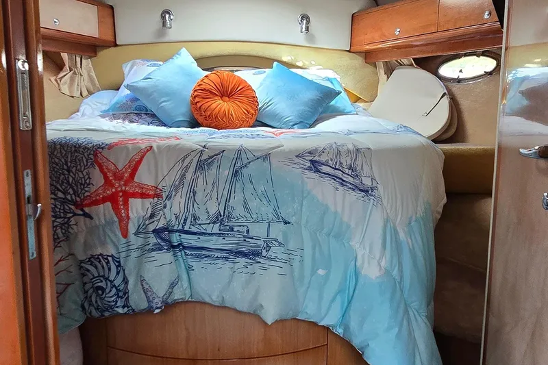 Slide: The Image of Cozy cabin bedroom in 2003 Regal Commodore 4260 yacht with nautical-themed bedding. - 33