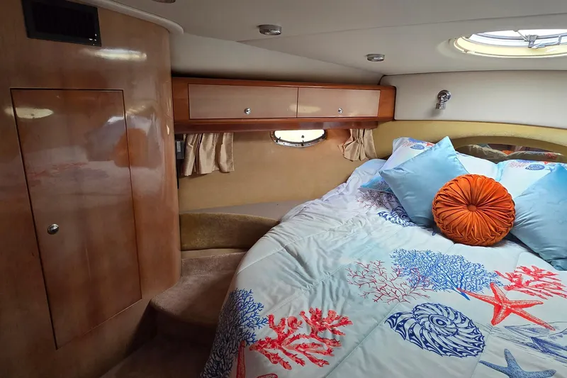 Slide: The Image of Luxurious cabin interior of 2003 Regal Commodore 4260 yacht with cozy bedding and wood accents. - 34