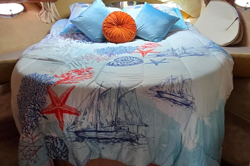 Slide: The Image of Cozy bed in 2003 Regal Commodore 4260 with nautical-themed bedding and colorful pillows. - 35
