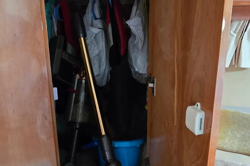 Slide: The Image of Open closet in 2003 Regal Commodore 4260, containing clothes and cleaning tools. - 39