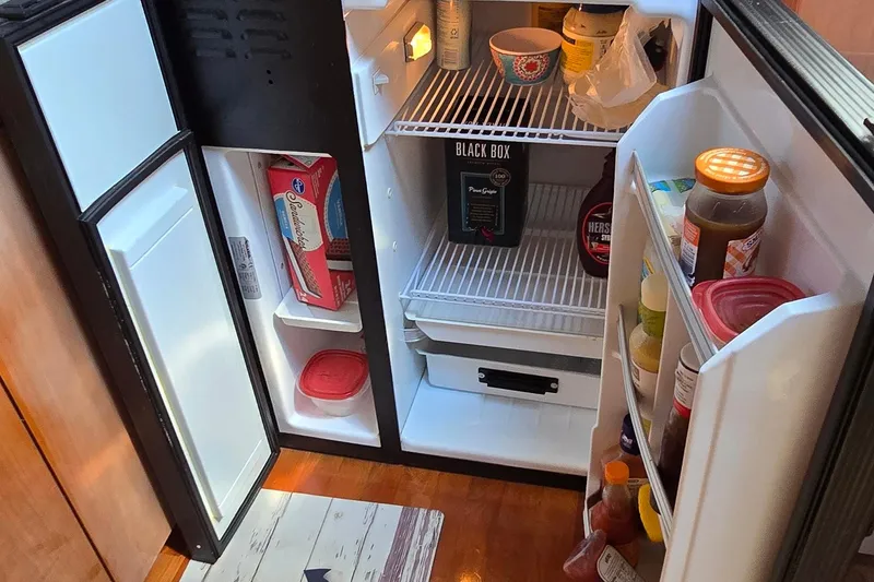 Slide: The Image of Refrigerator inside 2003 Regal Commodore 4260 yacht, stocked with various food items and beverages. - 50