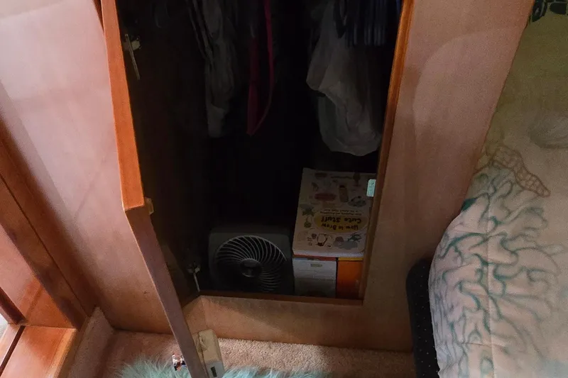 Slide: The Image of Open closet in 2003 Regal Commodore 4260, showing fan and box storage. - 54