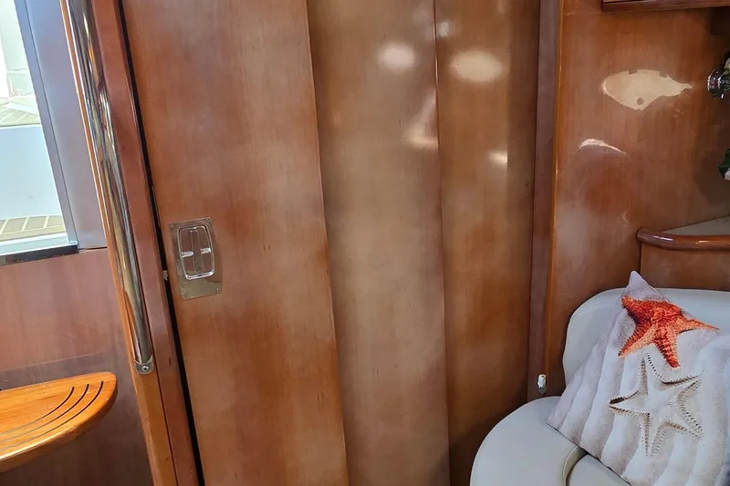 Slide: The Image of Interior of 2003 Regal Commodore 4260 yacht with wooden paneling and starfish-themed pillow. - 55