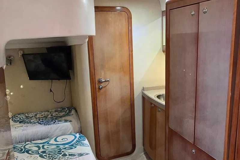 Slide: The Image of 2003 Regal Commodore 4260 cabin interior with wood finish, twin beds, and TV. - 56