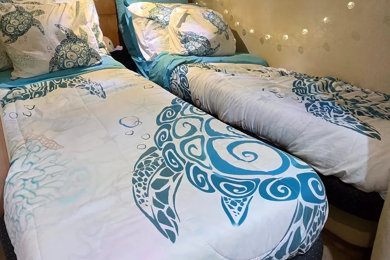 Slide: The Image of Twin beds with turtle-themed bedding in a cozy cabin setting. - 58