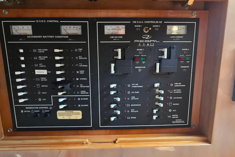 Slide: The Image of Control panel of a 2003 Regal Commodore 4260 boat, featuring electrical switches and gauges. - 65