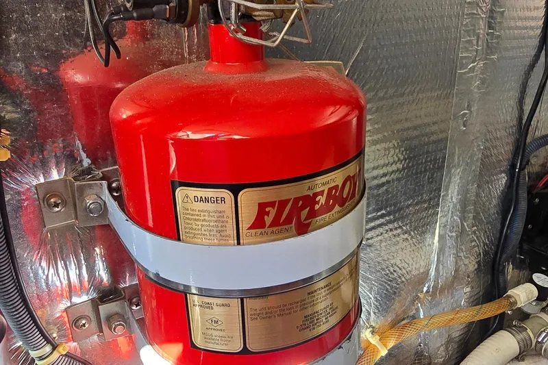 Slide: The Image of Fire extinguisher in 2003 Regal Commodore 4260 engine room, mounted securely with metal straps. - 71