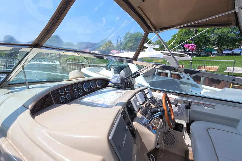 Slide: The Image of 1998 Sea Ray 370 Sundancer cockpit with steering wheel, gauges, and navigation equipment. - 12