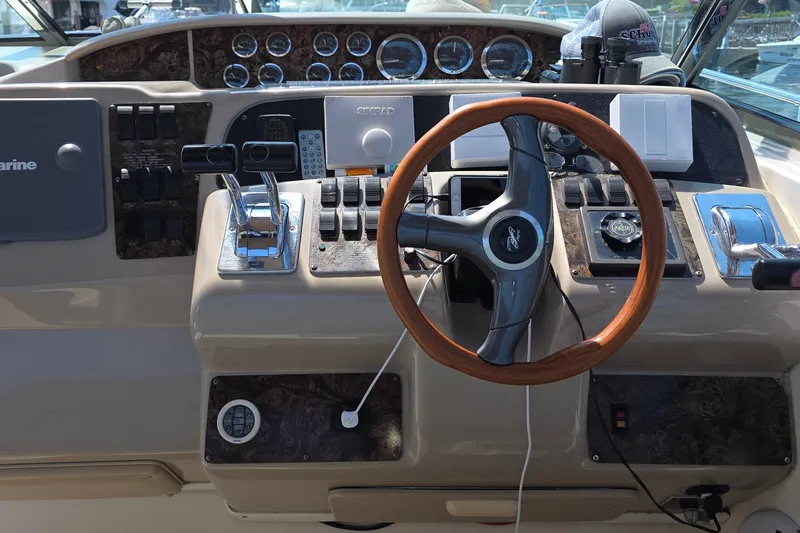 Slide: The Image of 1998 Sea Ray 370 Sundancer helm with wooden steering wheel and control panel. - 14