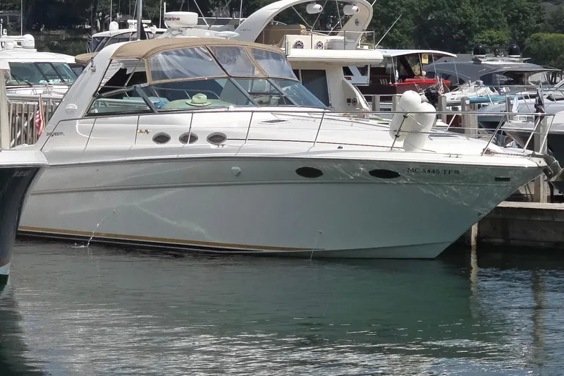 Slide: The Image of 1998 Sea Ray 370 Sundancer yacht docked in a marina, surrounded by other boats. - 2