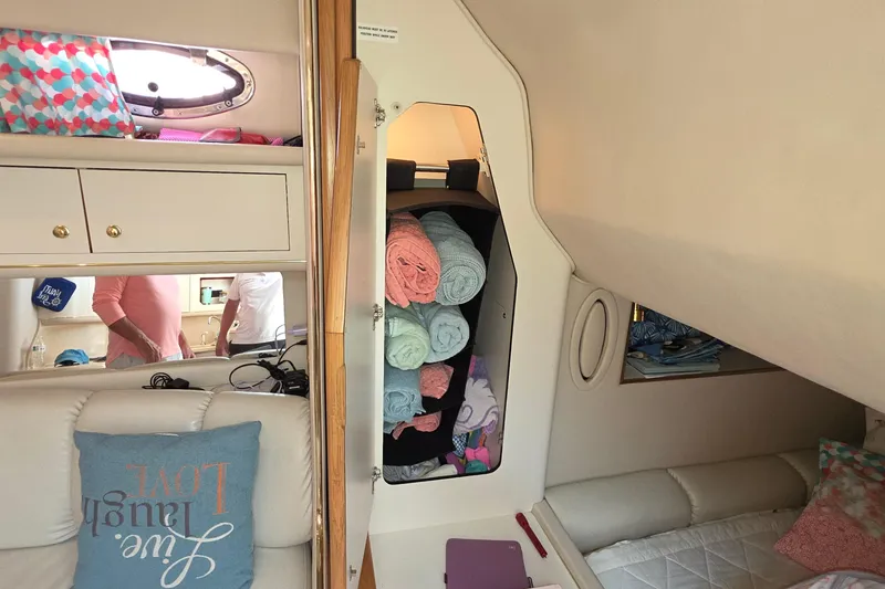 Slide: The Image of Interior of 1998 Sea Ray 370 Sundancer with storage, towels, and seating area. - 25