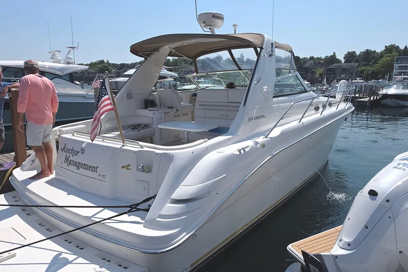 Slide: The Image of 1998 Sea Ray 370 Sundancer yacht docked in a marina, surrounded by other boats. - 3
