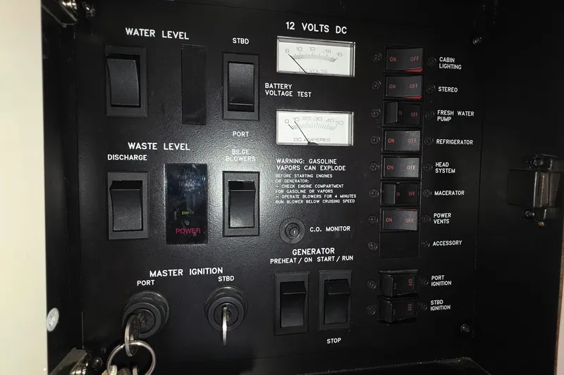 Slide: The Image of Control panel of a 1998 Sea Ray 370 Sundancer boat with various switches and gauges. - 32