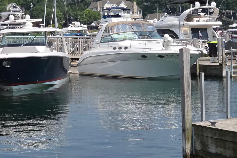 Slide: The Image of 1998 Sea Ray 370 Sundancer docked at a marina, surrounded by other boats. - 4