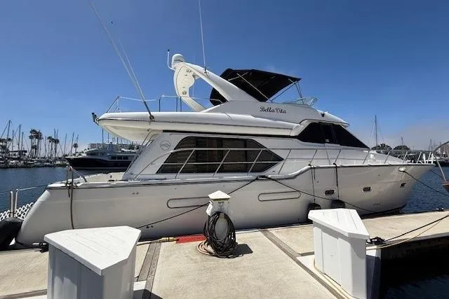 The Image of 2001 Bayliner 5288 Pilot House Motoryacht cruising in a marina under clear blue skies. - 0