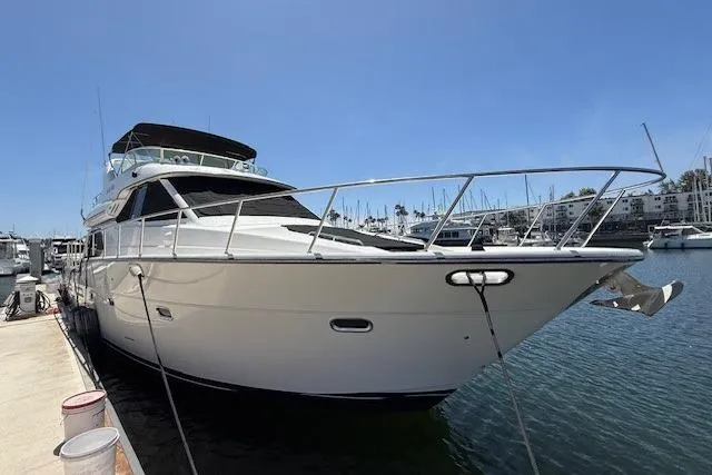 Slide: The Image of 2001 Bayliner 5288 Pilot House Motoryacht cruising in a marina under clear blue skies. - 1