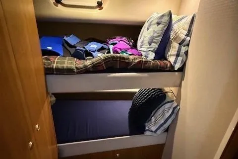 Slide: The Image of 2001 Bayliner 5288 Pilot House Motoryacht cabin with bunk beds and cozy bedding. - 30