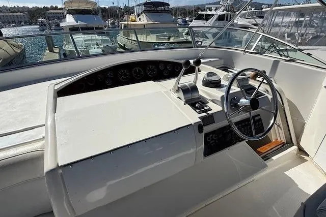 Slide: The Image of 2001 Bayliner 5288 Pilot House Motoryacht helm with steering wheel and controls, docked at marina. - 38