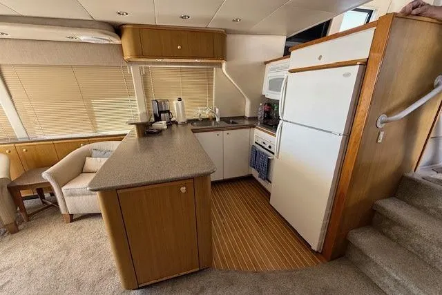 Slide: The Image of 2001 Bayliner 5288 Pilot House Motoryacht on water, clear sky, marina background. - 4