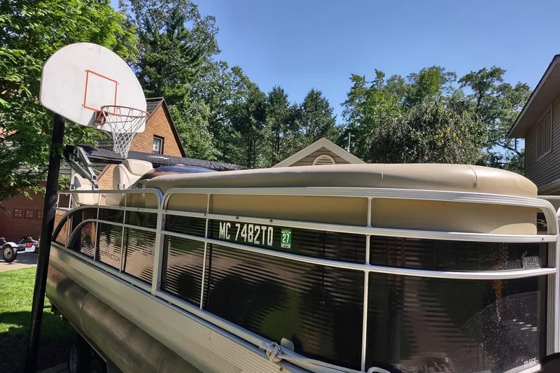 Slide: The Image of 2013 Bennington 22 SSX pontoon boat parked near a basketball hoop. - 11