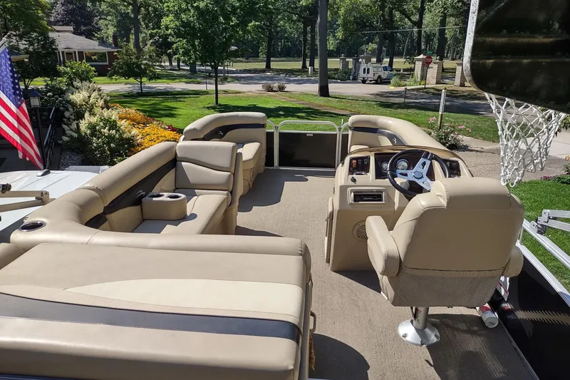 Slide: The Image of 2013 Bennington 22 SSX pontoon boat interior with beige seating and steering wheel. - 4