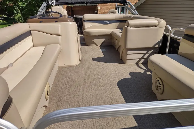Slide: The Image of 2013 Bennington 22 SSX pontoon boat interior with beige seating and carpet. - 5