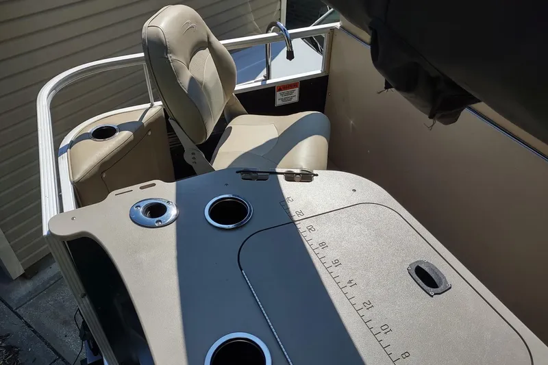 Slide: The Image of 2013 Bennington 22 SSX boat interior with beige seating and cup holders. - 8
