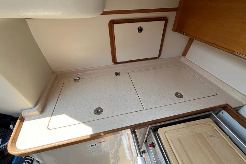 Slide: The Image of Compact kitchen area in a 2000 Catalina 320 sailboat, featuring a countertop and storage. - 15