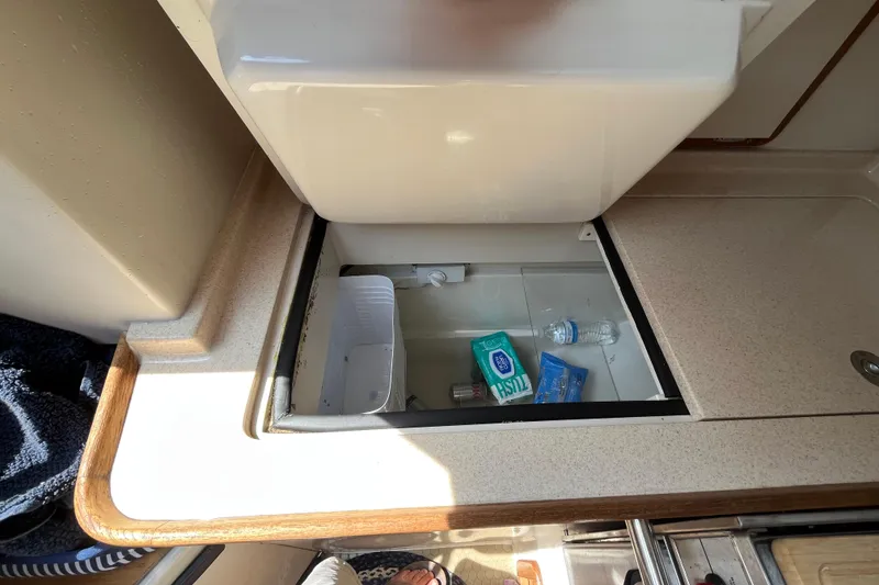 Slide: The Image of Storage compartment in 2000 Catalina 320 yacht with toiletries and water bottle. - 16