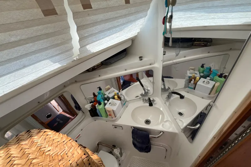 Slide: The Image of Compact bathroom in a 2000 Catalina 320 sailboat with dual sinks and storage. - 21