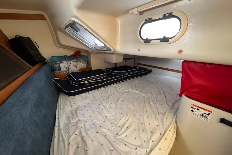 Slide: The Image of Cozy cabin interior of a 2000 Catalina 320 sailboat with bedding and cushions. - 22