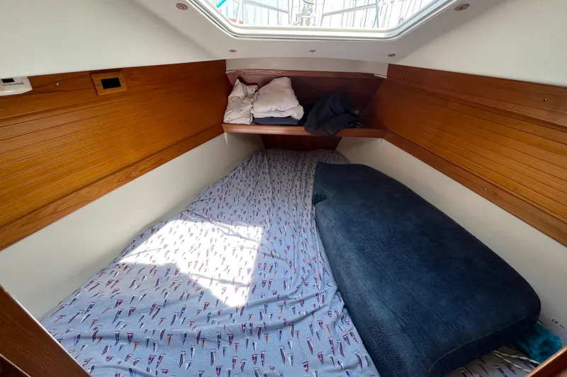 Slide: The Image of Cozy cabin interior of 2000 Catalina 320 sailboat with wooden paneling and bedding. - 24