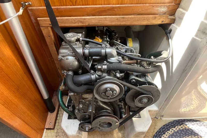 Slide: The Image of Engine compartment of a 2000 Catalina 320 sailboat, showcasing mechanical components and belts. - 26