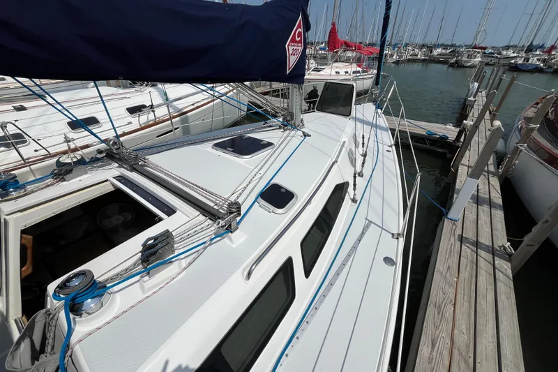 Slide: The Image of 2000 Catalina 320 sailboat docked at marina, showcasing deck and rigging details. - 5