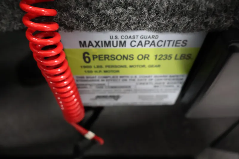 Slide: The Image of 2026 Crestliner 1850 Commander capacity label, 6 persons or 1235 lbs, red safety cord. - 23