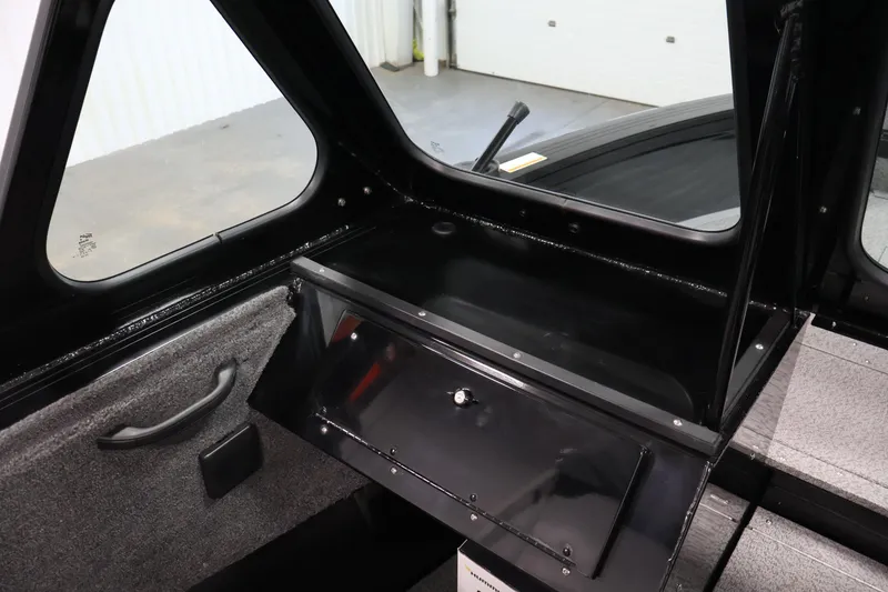 Slide: The Image of Interior view of 2026 Crestliner 1850 Commander boat, featuring storage compartment and window. - 25