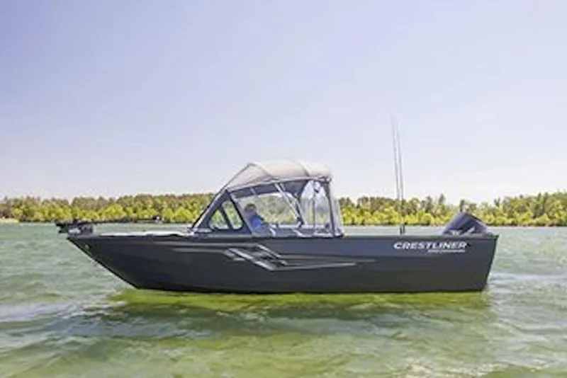 Slide: The Image of 2026 Crestliner 1850 Commander boat on a lake, clear sky, lush shoreline. - 5