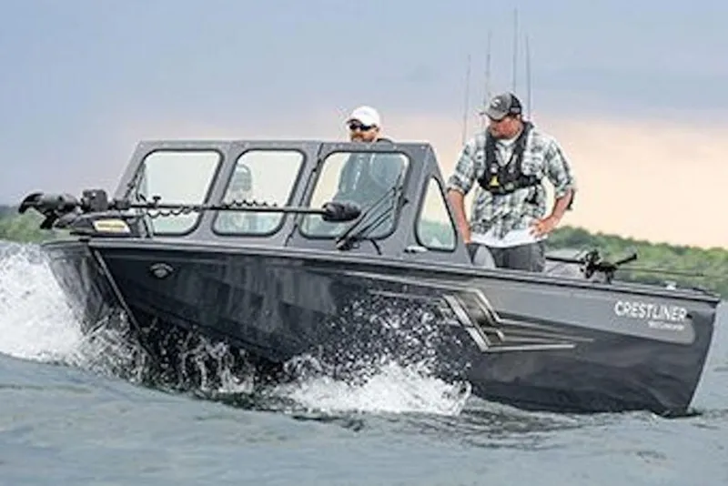 Slide: The Image of 2026 Crestliner 1850 Commander boat navigating choppy waters with two passengers onboard. - 6