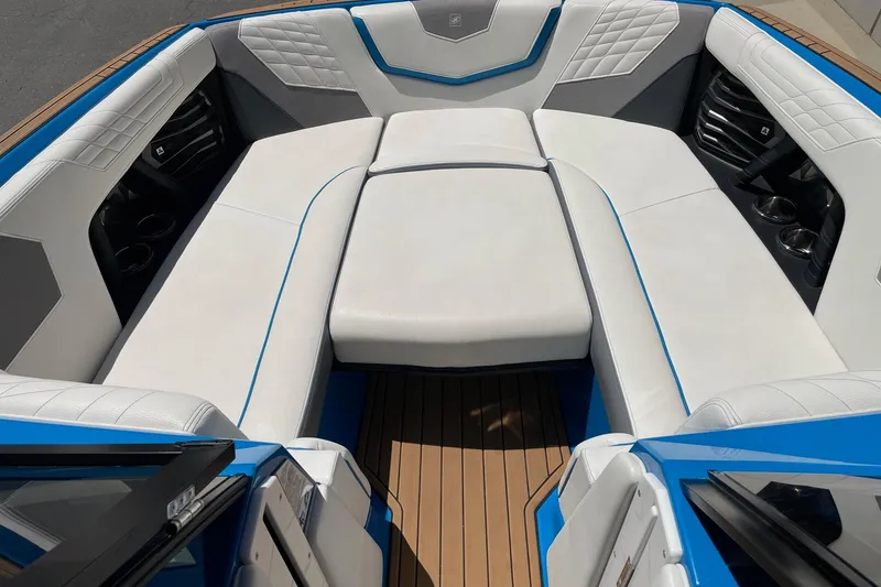 Slide: The Image of 2022 Nautique Super Air Nautique G25 interior with white seating and blue accents. - 13