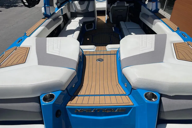 Slide: The Image of 2022 Nautique Super Air Nautique G25 interior with blue accents and teak flooring. - 6