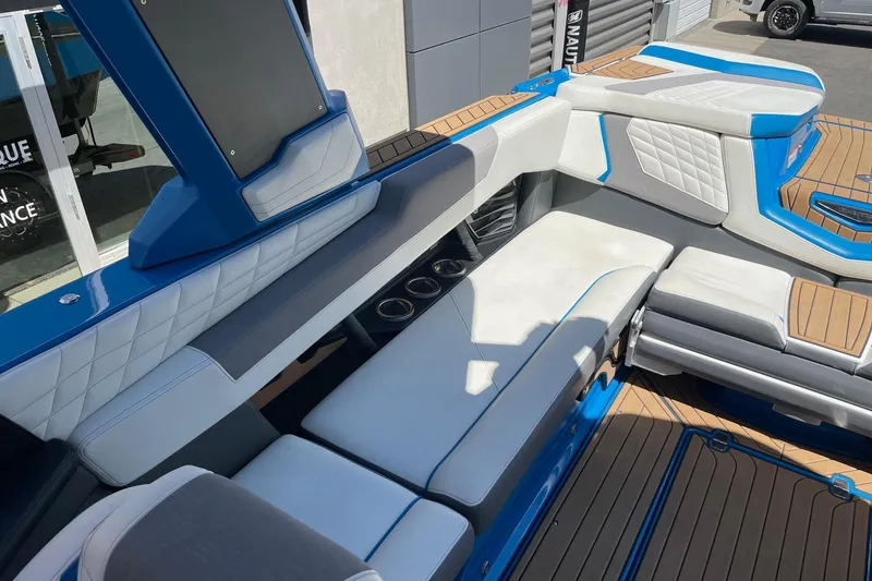 Slide: The Image of 2022 Nautique Super Air Nautique G25 interior with blue and white seating, luxury design. - 9